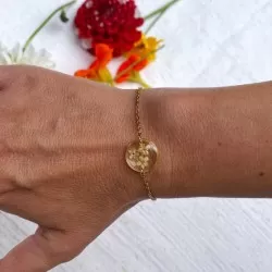 Bracelet en acier inoxydable doré avec inclusion de fleurs de sureau inclu dans de la résine transparente porté - bijou fleur