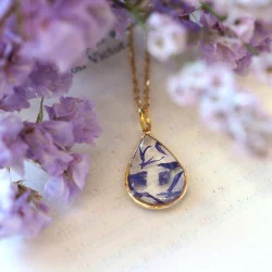 Collier en laiton doré à l'or fin avec fleurs de bleuet posé sur une main - collier fleur - Bijoux vraies fleurs Clermont