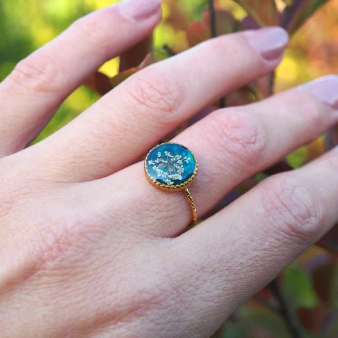 Bague en acier inoxydable doré en fleurs de carotte sauvage sur un fond émeraude - bijou vrai fleur Clermont