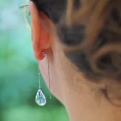 Boucle d'oreille goutte en acier inoxydable avec inclusion de fleurs de bleuet portée sur une oreille