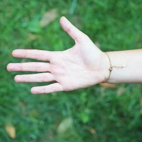 Arrière de bracelet rond en acier inoxydable doré avec inclusion de fleur de pensée dans de la résine transparente porté