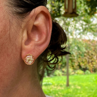 Puces d'oreilles en acier inoxydable doré avec inclusion de fleur de carotte sauvage dans de la résine transparente portées