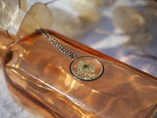 Collier rond en acier inoxydable argenté avec inclusion de fleur de carotte sauvage dans de la résine transparente