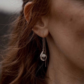 Boucle d'oreille en laiton doré à l'or fin avec inclusion de fleurs de gypsophile portée à l'oreille - bijou fleur