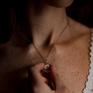 Collier hexagone en laiton doré à l'or fin avec inclusion de fleurs de gypsophile porté autour du cou - collier fleur