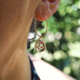 Créoles en acier inoxydable doré avec inclusion de fleurs d'alysse portées à une oreille - Bijou fleur Clermont