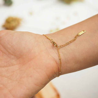 Arrière de bracelet losange en acier inoxydable doré avec inclusion de fleurs d'alysse porté au poignet