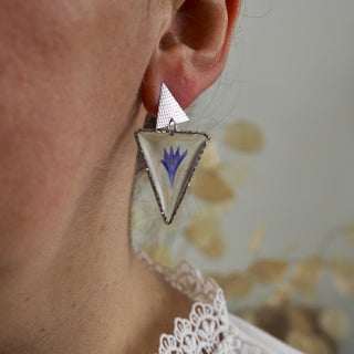 bijou fleur - Boucle d'oreille argentées en forme de  triangle avec inclusion d'une fleur de bleuet bleue portée à une oreille