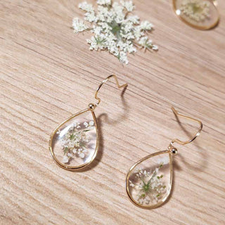Petites boucles d'oreilles gouttes en laiton doré avec inclusion de fleur de carotte sauvage dans de la résine transparente
