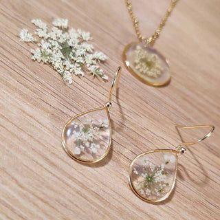 Petites boucles d'oreilles gouttes en laiton doré avec inclusion de fleur de carotte sauvage dans de la résine transparente
