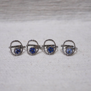 Bague réglable argentée myosotis bleu sur fond blanc, chaque fleur est différente