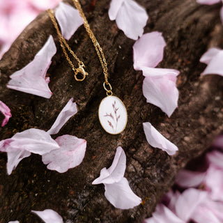 Bijou fleur clermont-ferrand - Collier doré avec de la poacée sur fond blanc.