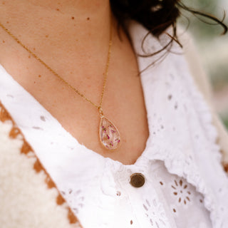Bijou en fleurs séchées - Collier doré en forme de goutte avec des fleurs d'Alysse roses porté