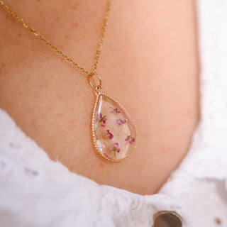 Bijou en fleurs séchées - Collier doré en forme de goutte avec des fleurs d'Alysse roses porté 2