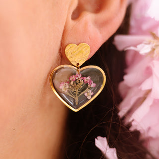 Bijou en fleurs séchées - Boucles d'oreilles en forme de coeur avec des fleurs d'alysse roses portées -  Bijou fleur