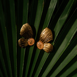 Bijou fleurs clermont - Boucles d'oreilles en forme d'aile de papillon en fleurs de carotte sauvage sur fond de couleur pêche.
