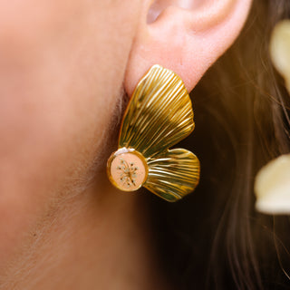 Bijou en fleurs séchées - Boucles d'oreilles en forme d'aile de papillon en fleurs de carotte sauvage sur fond pêche portées 2