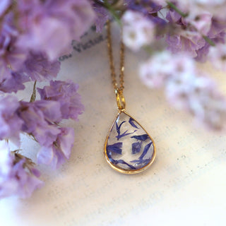 Collier en laiton doré à l'or fin avec fleurs de bleuet posé sur une main - collier fleur - Bijoux vraies fleurs Clermont