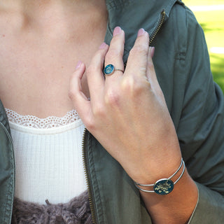 Bague en acier inoxydable argentée en fleurs de carotte sauvage sur un fond émeraude - Bijoux en fleurs Clermont