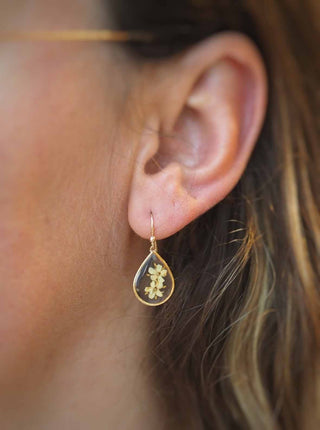 Boucles en acier inoxydable doré avec inclusion de fleurs de sureau inclu dans de la résine transparente portées - bijou fleur