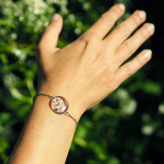 bracelet argenté avec inclusion de fleurs de bleuet porté sur un poignet