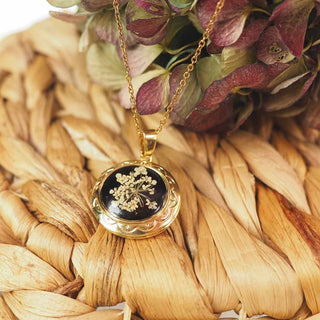 Médaillon en acier inoxydable doré avec inclusion de fleur de carotte sauvage dans de la résine noire - collier fleur