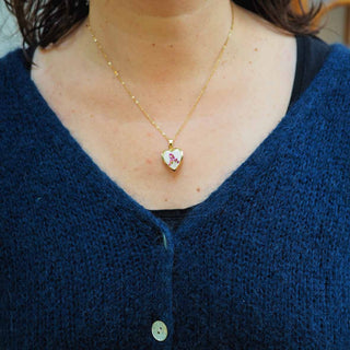 Médaillon losange en acier inoxydable avec inclusion de fleurs d'alysse dans de la résine blanche porté - collier fleur